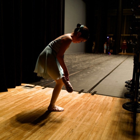 A lone dancer rehearsing on an empty stage