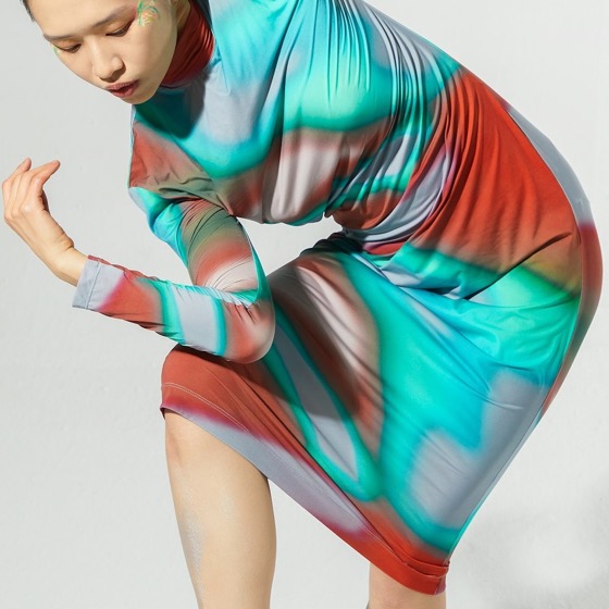 A dancer mid-movement against a plain studio backdrop