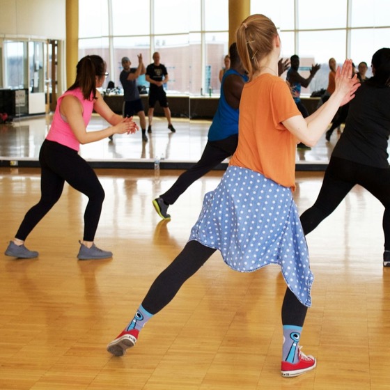 An adult dance class in a mirrored studio