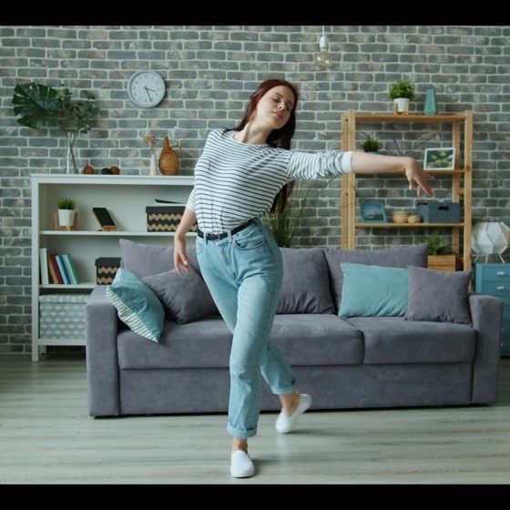 A woman dancing in her living room at home
